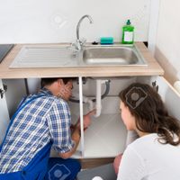 44339844-Plumber-Showing-Damage-In-Sink-Pipe-To-Woman-Plumber-At-Home-Stock-Photo.jpg